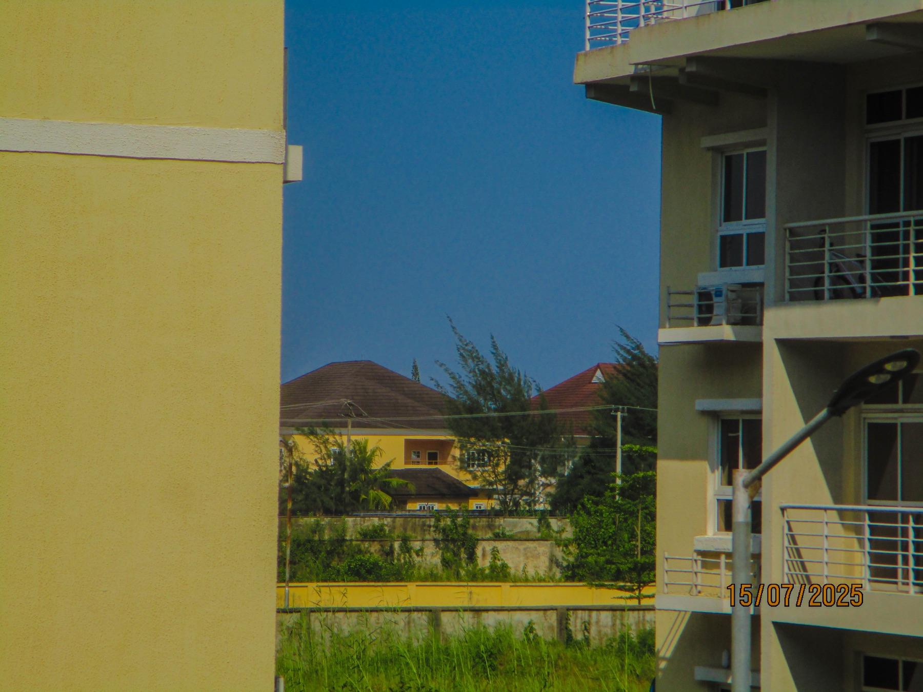 Rooftops seen through the gap between two yellow buildings