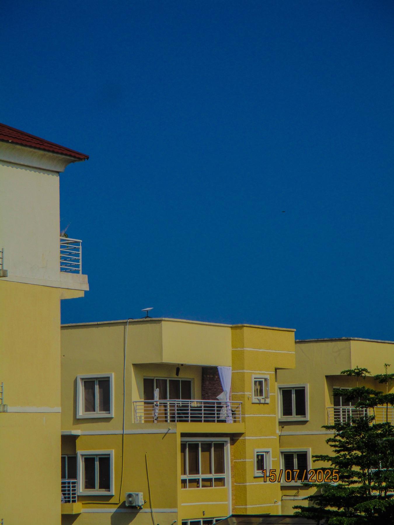 Yellow apartment blocks against a deep blue sky